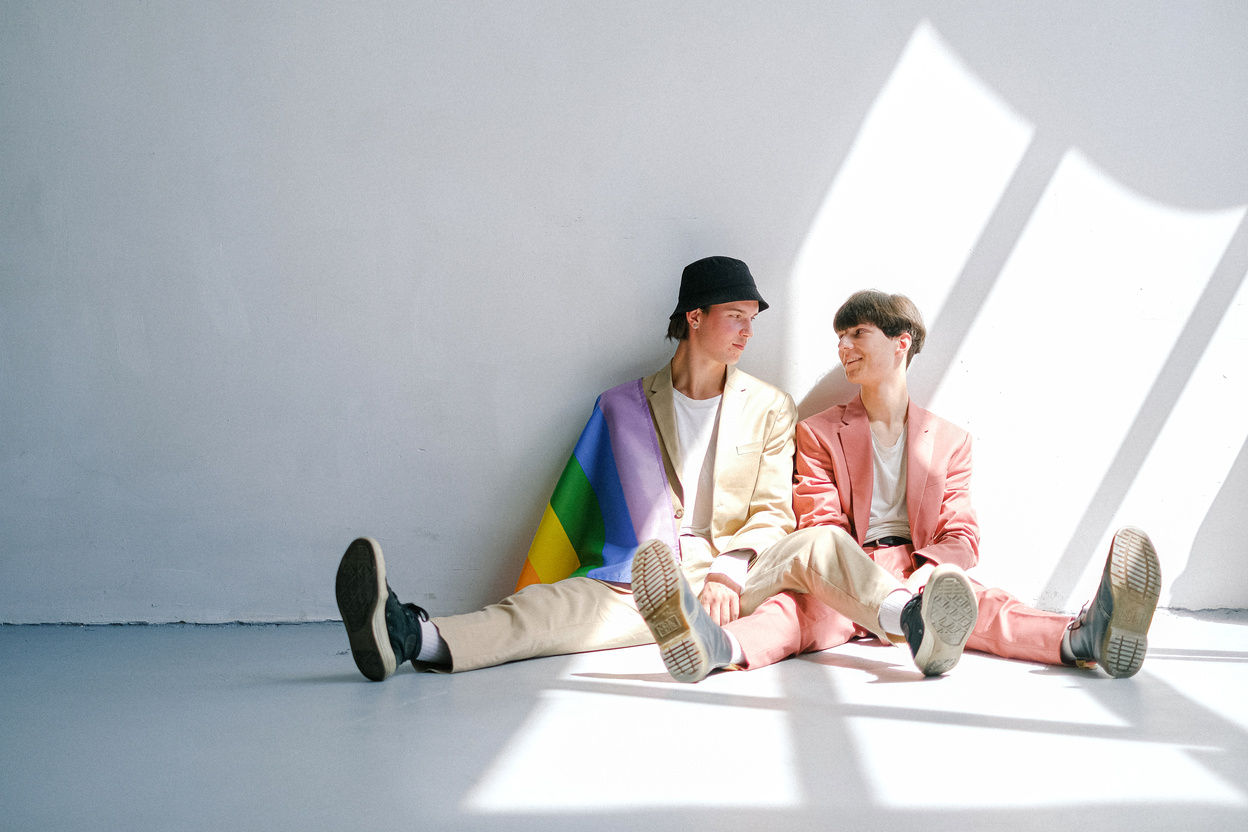 Two Men Sitting on the Floor with a Gay Pride Flag